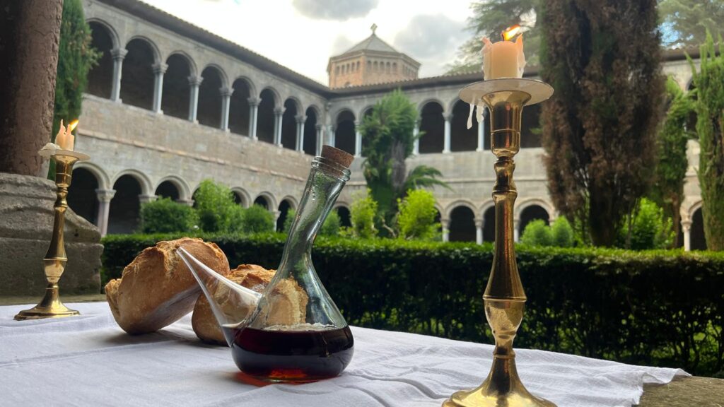 Dos pans, dues espelmes i un porró de vi al claustre del monestir de Ripoll